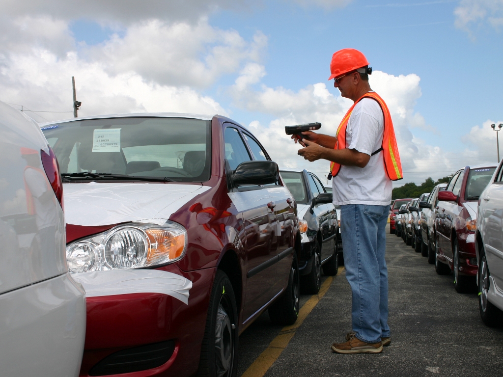Crowley employee inspecting a car and verifying paperwork for shipment from Puerto Rico to the U.S.